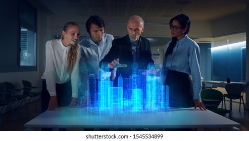 A group of modern designers are using a futuristic sophisticated technology screen with augmented reality holograms for a new project realization in an office. - Powered by Shutterstock