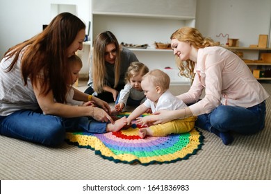 Group of mothers with babies in a lesson at a kindergarten center, Montessori kindergarten mom and baby, caucasian women with children