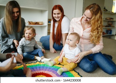 Group Of Mothers With Babies In A Lesson At A Kindergarten Center, Montessori Kindergarten Mom And Baby, Caucasian Women With Children