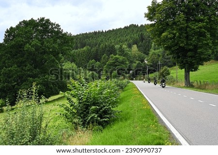 Group of Motorcyclists take a tour through the hilly landscape of the Belgian Ardennes