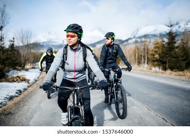 Group of mountain bikers riding on road outdoors in winter. - Powered by Shutterstock