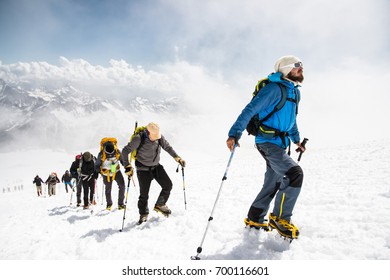 A group of mountaineers climbs to the top of a snow-capped mountain - Powered by Shutterstock