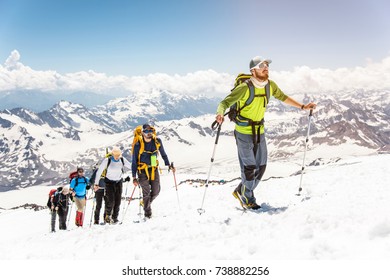 A group of mountaineers climbs to the top of a snow-capped mountain - Powered by Shutterstock