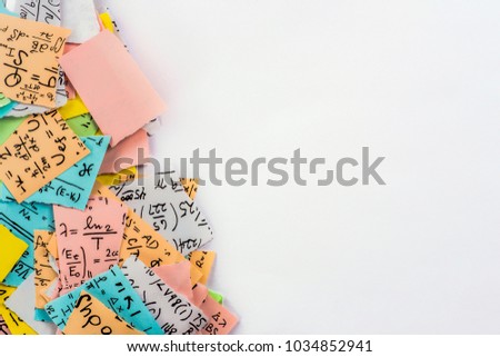 A group of multi colored crumpled paper with mathematical equations. A bunch of multi colored torn paper with mathematical equations on it, background. Crumpled multi colored paper ball.