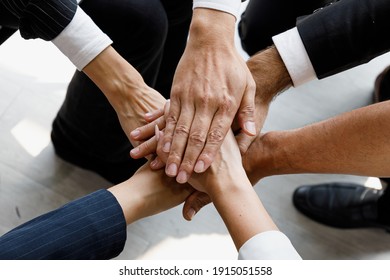 Group Of Multi Colors Hands Stack Together And Smiling In The Symbol Of Unity And Strong Teamwork.