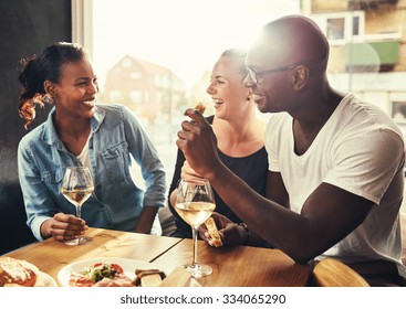 Group Of Multi Ethnic Friends Drinking Wine At A Cafe Outside