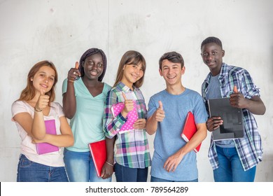 Group of multi ethnic teenagers smiling happy standing with their school notebooks, isolated on white background.