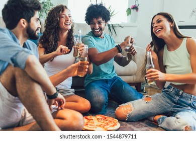 Group Of Multi Ethnic Young Friends Eating Pizza At Home And Having Fun.