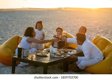 Group Of Multi Generation Asian Family Enjoy Dinner Party On The Beach At Sunset. Diverse Family With Child Girl, Adult And Senior Couple Relax And Having Fun Together On Summer Holiday Vacation