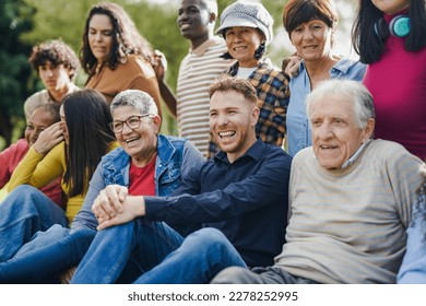 Group of multi generational people having fun together outdoor - Multiracial friends enjoy day at city park - Shutterstock ID 2278252995