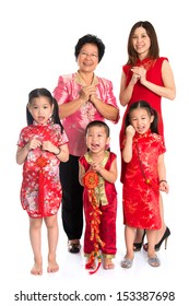 Group Of Multi Generations Asian Chinese Family Wishing You A Happy Chinese New Year, With Traditional Cheongsam Standing Isolated On White Background.