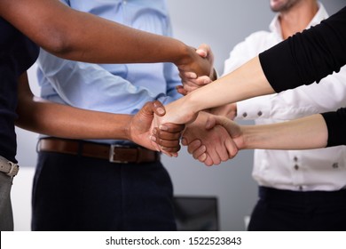 Group Of Multi Racial Businesspeople Shaking Hands With Each Other In Office