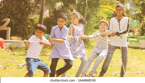 Group Of Multi Racial Children Playing Tug Of War Game Kindergarten - Multi Ethnic Kids Playing Outdoor Games Against Racism