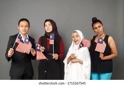 A Group Of Multi Racial Malaysian Youngsters Waving The Flags Celebrating Merdeka Day Or Independence Day.                               