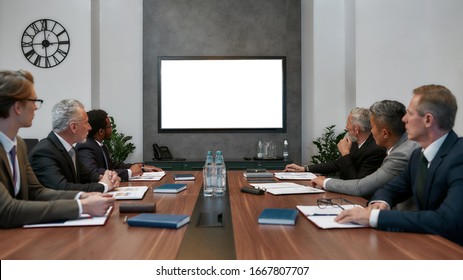 Group Of Multicultural Business People Having Video Conference While Sitting In The Meeting Room. Business Team Looking At Screen. Business Meeting. Teamwork. Office Life