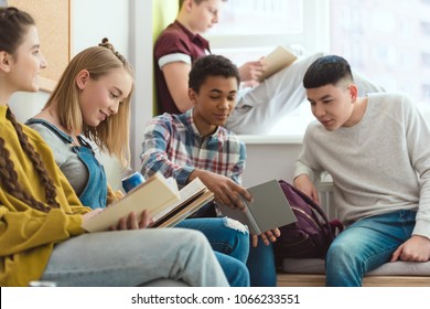 Gruppe multikultureller High School-Teenagerschüler, die während der Schulpause Hausaufgaben machen 