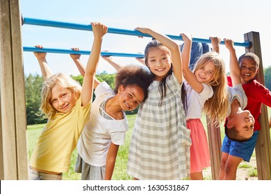 Group Of Multicultural Kids On A Sports Equipment Or Playground