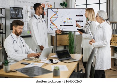 Group of multicultural medical workers discussing gene modification while gathering at hospital meeting room. Qualified doctors researching dna peculiarities during international conference. - Shutterstock ID 2164650263