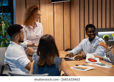 Group of multicultural professionals engaged in teamwork and brainstorming, sharing ideas and charts in modern office setting - Powered by Shutterstock - Get 15% off with code: PIKWIZARD15