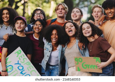 Group of multicultural teenagers smiling happily while standing together at a climate change protest. Diverse youth activists joining the global climate strike. - Shutterstock ID 2168160353