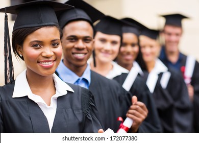 group of multicultural university graduates standing in a row