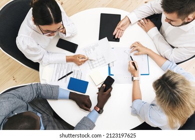 Group Of Multi-ethnic Business People During Meeting In Modern Office Sitting At The Round Table