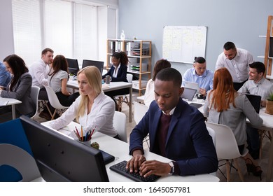 Gruppe der multiethnischen Geschäftsleute, die im Büro Computer arbeiten