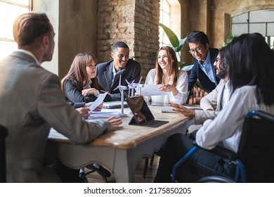 Group of multiethnic businesspeople working on financial strategy, renewable power, sustainable innovation project, and environmental economical issues, while smiling and having a positive interaction - Powered by Shutterstock