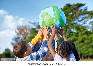 Group of multiethnic children holding model of earth in park with copy space. Primary students holding a big handmade earth model and raising it high. Save the planet, earth day and global peace. - Powered by Shutterstock