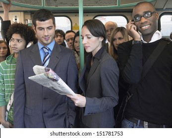 Group of multiethnic commuters in a train with woman reading newspaper - Powered by Shutterstock