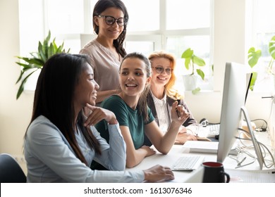 Group Multi-ethnic Co-workers Girls Teammates Enjoy Break Having Fun Chatting Sit At Shared Office Desk. Mentoring, International Creative Department Workday, Help, Internship, Common Project Concept