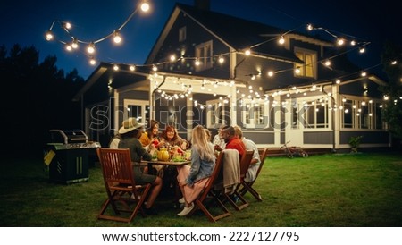 Group of Multiethnic Diverse People Having Fun, Communicating with Each Other and Eating at Outdoors Dinner. Family and Friends Gathered Outside Their Home on a Warm Summer Evening.