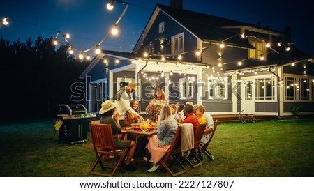Group of Multiethnic Diverse People Having Fun, Sharing Stories with Each Other and Eating at Outdoors Dinner Party. Family and Friends Gathered Outside Their Home on a Warm Summer Evening.