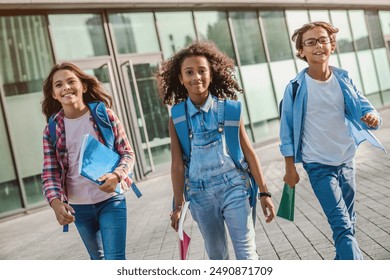 Group of multiethnic elementary middle school kids children pupils classmates walking after school outdoor running out outside at the end of the lessons. Finish welcome back school concept. - Powered by Shutterstock