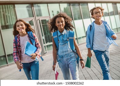 Group of multiethnic elementary school kids walking after school lessons outdoor