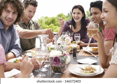 Group Of Multiethnic Friends Enjoying Dinner Party Outdoors