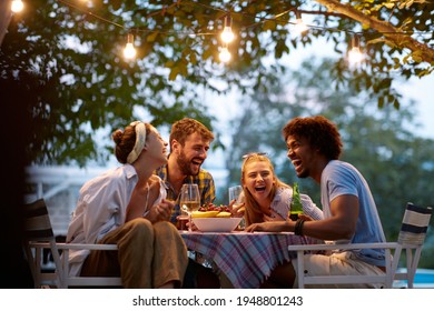 group of multiethnic friends laughing, gathered, talking, sitting at the outdoor table, socializing, - Powered by Shutterstock