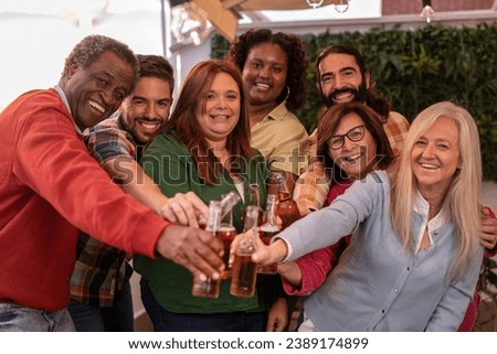 group of multiethnic friends looking at camera to take a photo. several generations of friends celebrating