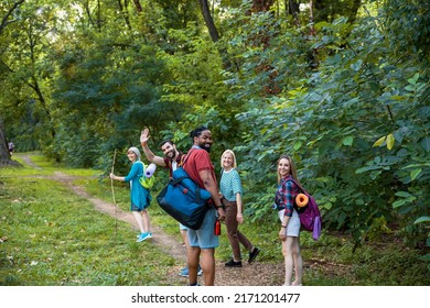 Group Of Multiethnic Friends On Trekking In Green Forest Trail. Happy Young Diverse People Walking In Woods, Smiling And Enjoying