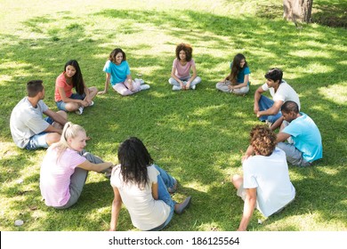 Group Of Multiethnic Friends Sitting In A Circle At Park