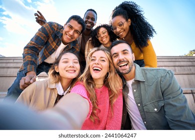 Group of multiethnic friends taking selfie with smart mobile phone outdoors. Happy young multiracial people smiling together looking at camera. University students having fun in college campus - Powered by Shutterstock