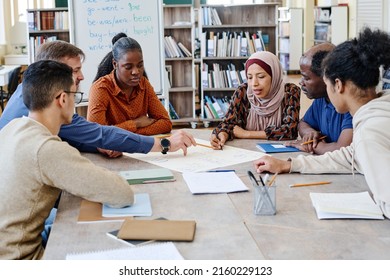 Group of multi-ethnic immigrant students attending international school lessons working on English language poster together
