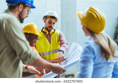 Group of multiethnic industrial employees planning building project and meeting on panoramic terrace. Four international colleagues using computer and technical plan for remodeling business center. - Powered by Shutterstock