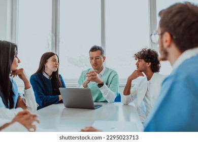 A group of multiethnic medical professionals including doctors, surgeons, and nurses are gathered in a hospital setting discussing patient care and using modern technology to address challenges in - Powered by Shutterstock