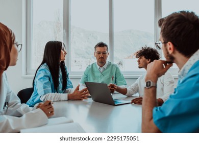 A group of multiethnic medical professionals including doctors, surgeons, and nurses are gathered in a hospital setting discussing patient care and using modern technology to address challenges in - Powered by Shutterstock