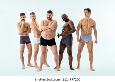 Group of multiethnic men posing for a male edition body positive beauty set. Shirtless guys with different age, and body wearing boxers underwear - Shutterstock ID 2114997200