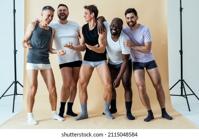 group of multiethnic men posing for a male edition body positive beauty set. guys with different age, and body wearing boxers underwear