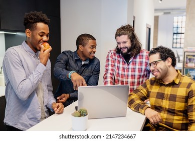 group of multiethnic and multiracial coworkers take a break in their office lunchroom to watch multimedia content on a laptop computer. - Shutterstock ID 2147234667