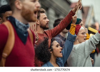 Group of multiethnic people protesting outdoors with placards and signs. People shouting with banners protest as part of a climate change march. Protestors holding worker rights banners at protest. - Shutterstock ID 1751770574