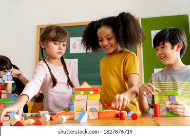 Group Of Multiethnic School Friends Using Toy Blocks In Classroom, Education, Learning, Teamwork. Children Playing With Wooden Blocks In Classroom